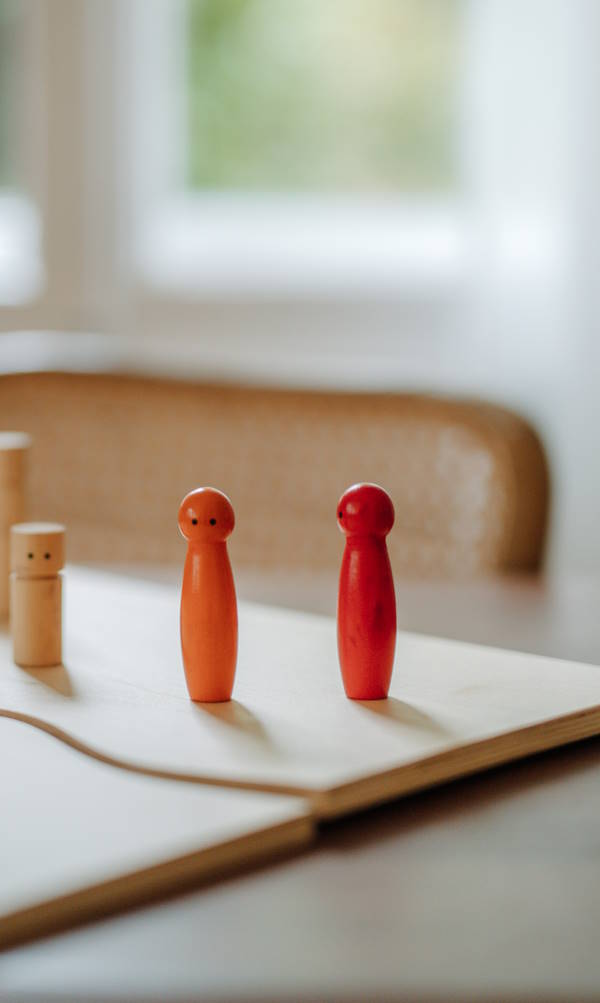 Psychotherapie bei Phobien | 2 rote Holzfiguren stellvertretend für panikauslösende Situationen